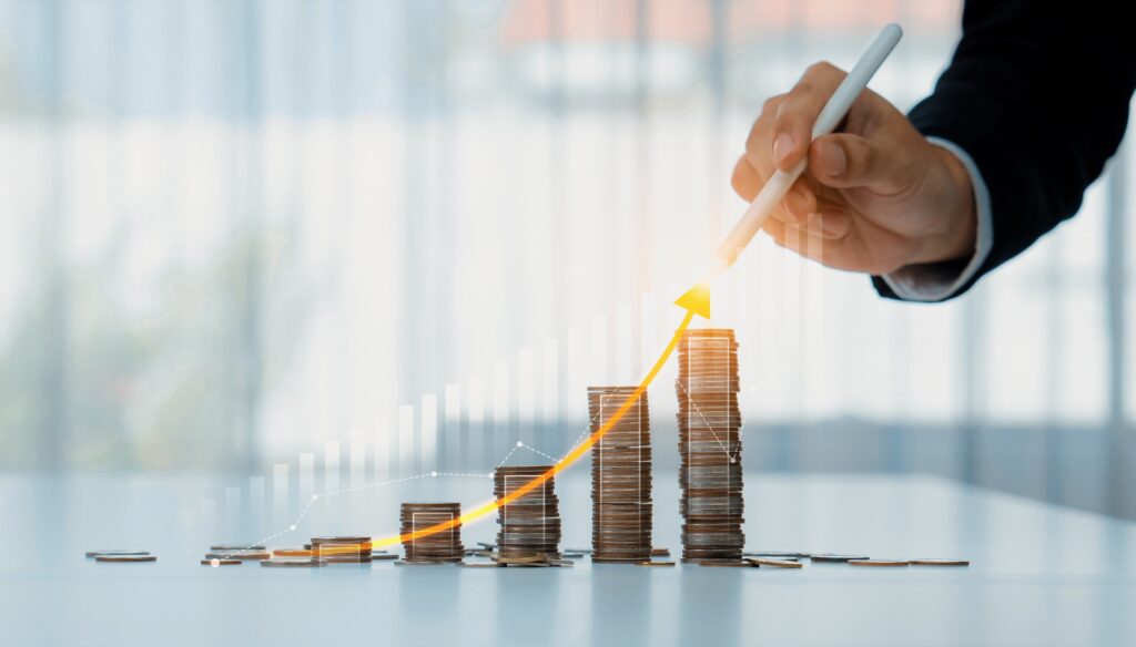 Stack of coins beside a rising investment chart, symbolizing tax savings from real estate professional status.